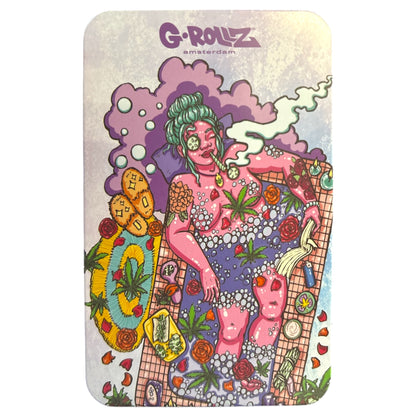 G-Rollz metal storage tin lid featuring colourful psychedelic artwork with a green-haired character, pink clouds, mushrooms, smiley faces, and assorted cartoon illustrations.
