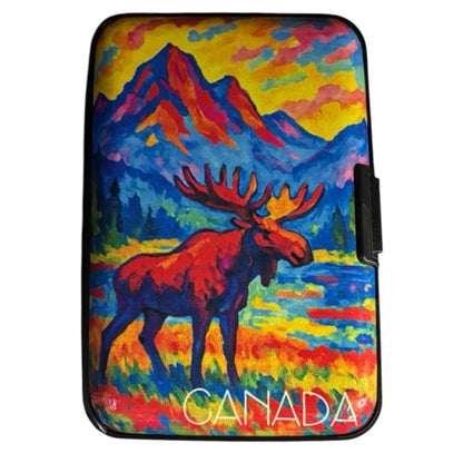 Slim hard shell Canada card wallet with a colourful textured oil painting style print of a red moose standing in front of a lake, blue mountains, yellow sky, and bright Canadian wilderness scenery. The word “CANADA” is printed in white at the bottom. - The Wee Smoke Shop