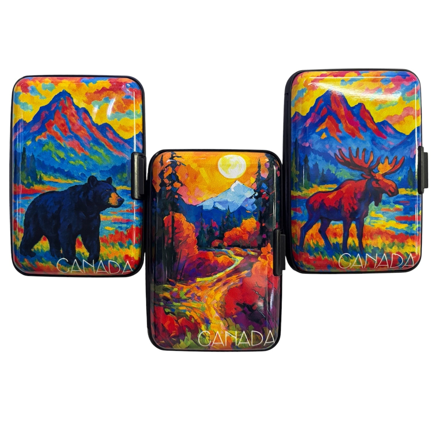 Assorted slim hard shell Canada card wallets featuring colourful textured oil painting style prints of Canadian landscapes, including a black bear by a mountain lake, an autumn forest path under a full moon, and a moose in front of blue mountains. The Wee Smoke Shop