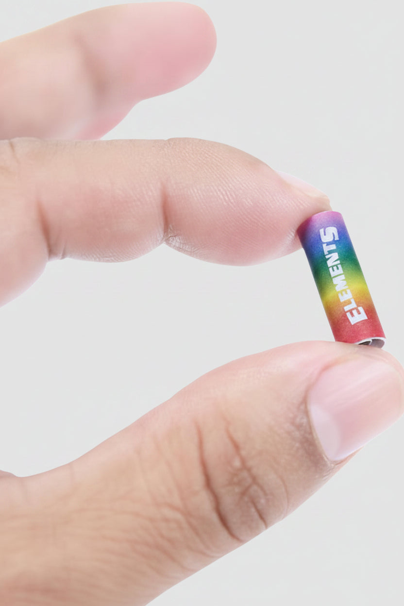 Small cylindrical Filter tips with rainbow-colored label held between fingers against a white background