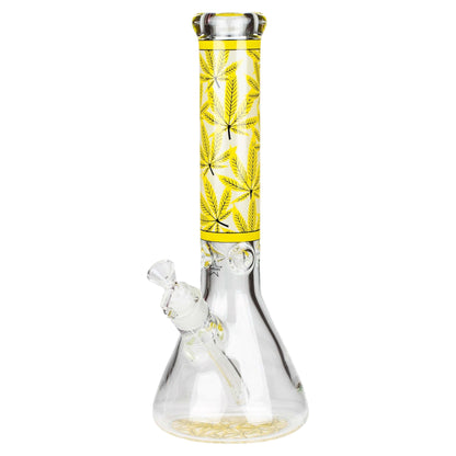 Glass smoking device with yellow chamber featuring cannabis leaf design on a white background