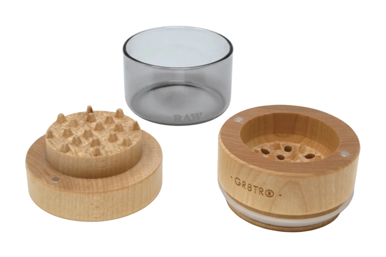 Wooden grinder and clear glass container on a white background
