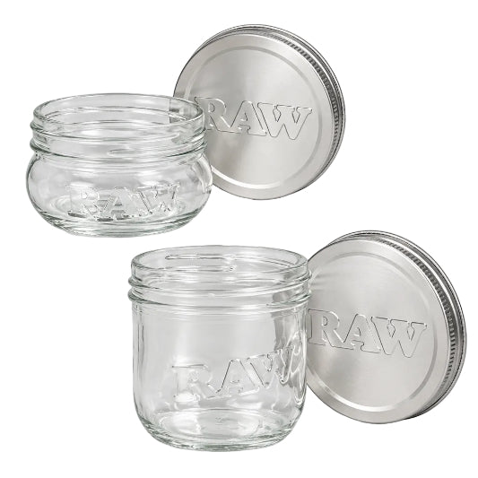 Two clear RAW glass mason jars shown with silver RAW-branded lids, featuring raised RAW lettering on the glass and embossed RAW text on the lids.