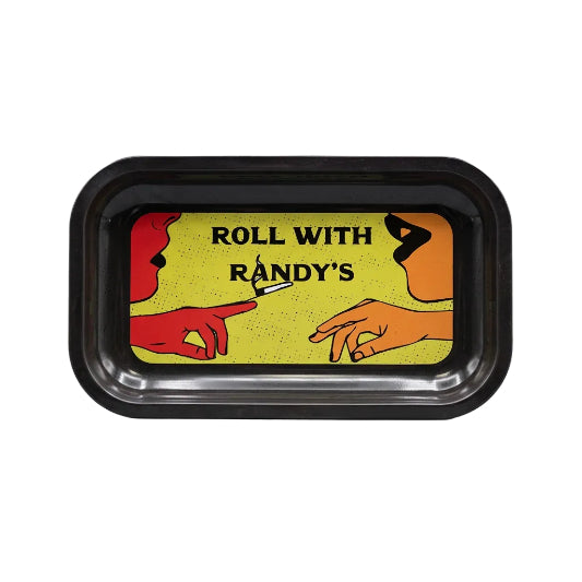 Black rectangular metal rolling tray with rounded corners and raised edges, featuring a yellow speckled background, bold "Roll With Randy's" lettering, and a pop art illustration of two people facing each other, with a red hand holding a lit joint toward an orange hand.