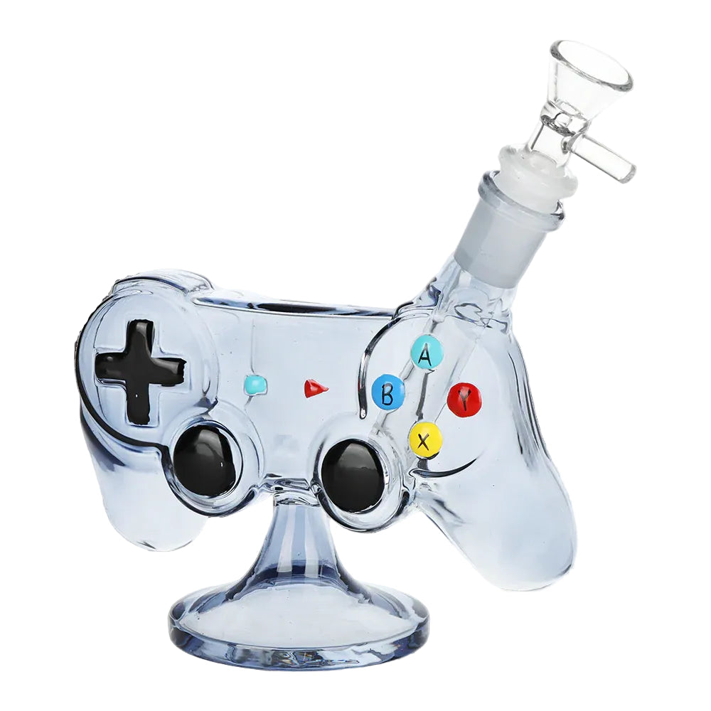 Clear blue game controller bong with black joysticks, coloured buttons, glass bowl, and pedestal base. The Wee Smoke Shop