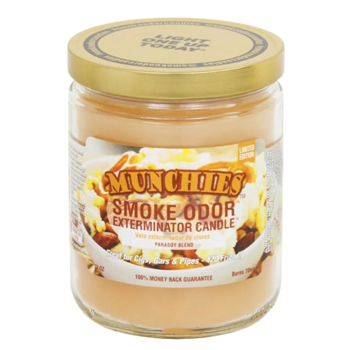 A clear glass Smoke Odor Exterminator candle jar with a label that includes the product name and the scent 'Munchies'. The jar is filled with a beige wax and has a gold lid.