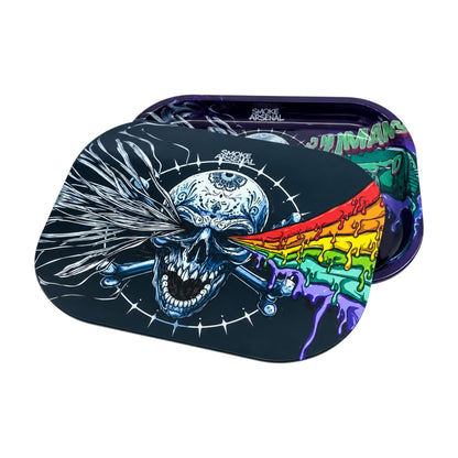 Angled view of the Smoke Arsenal Stoned Skull magnetic rolling tray cover featuring a blue skull, rainbow dripping artwork, silver streaks, and rounded rectangular edges on a white background.