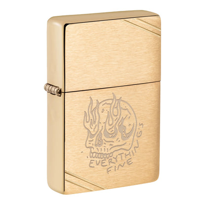 Gold Zippo windproof lighter with a brushed finish, engraved flaming skull illustration, "Everything Fine" lettering beneath the skull, and diagonal line accents in opposite corners. Features a visible gold side hinge and classic flip-top lid on a white background.