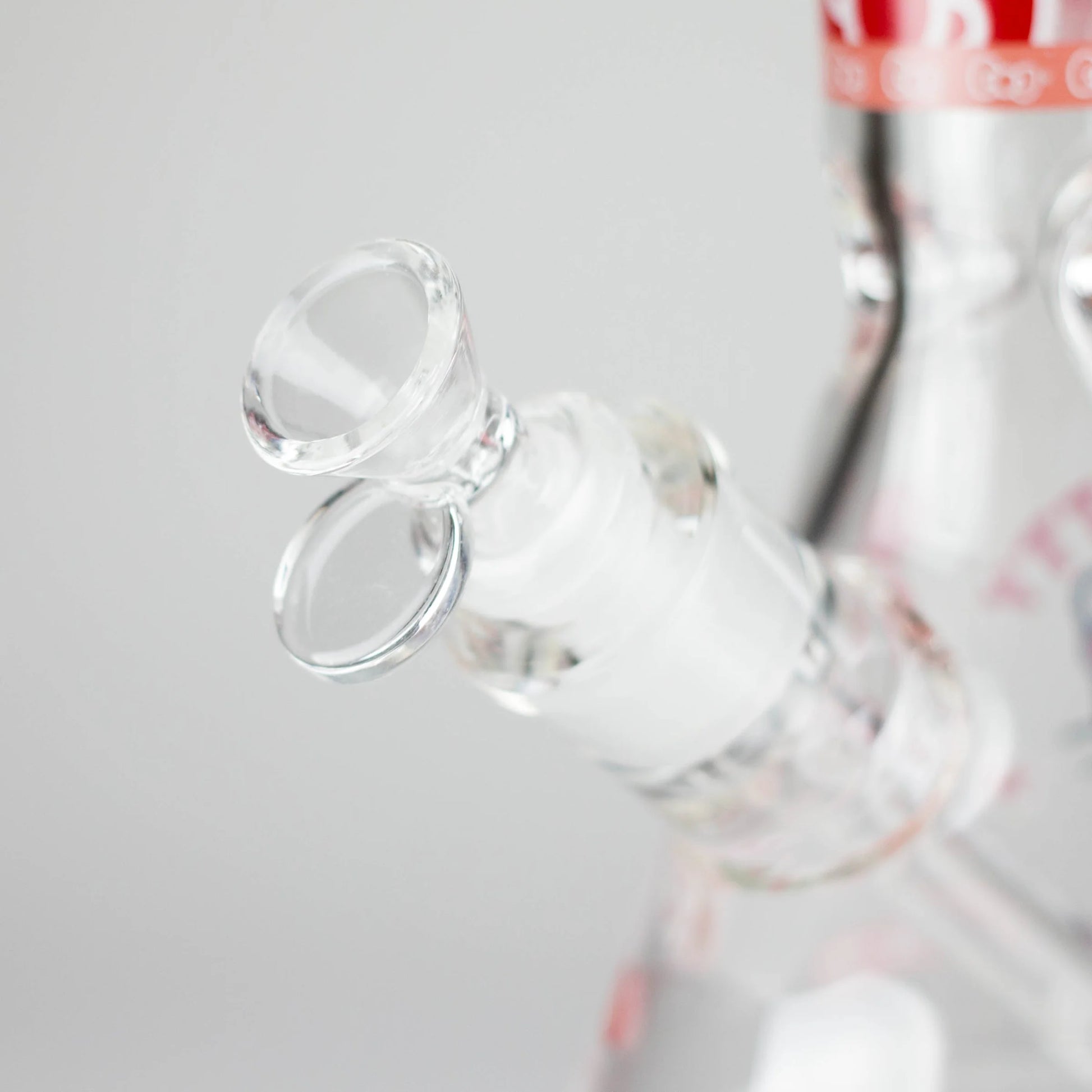 Close-up of a clear glass bottle with a white label on a light gray background
