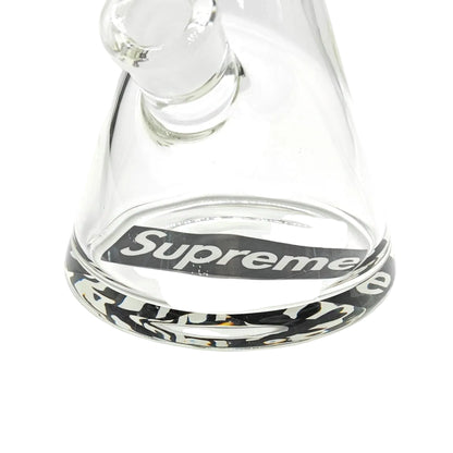 Clear glass water pipe with 'Supreme' logo on a white background