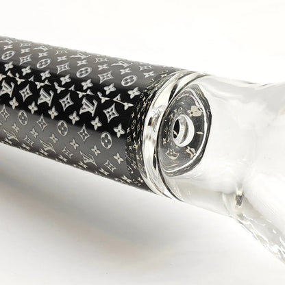 Glass pipe with black and white patterned sleeve on a white background